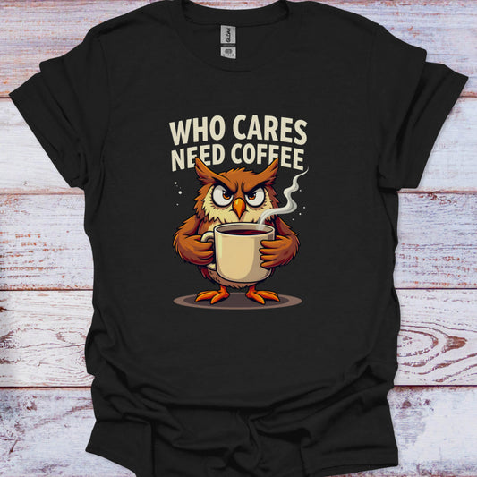 Black t-shirt with an owl holding a coffee cup and text 'WHO CARES NEED COFFEE' on a wooden surface.