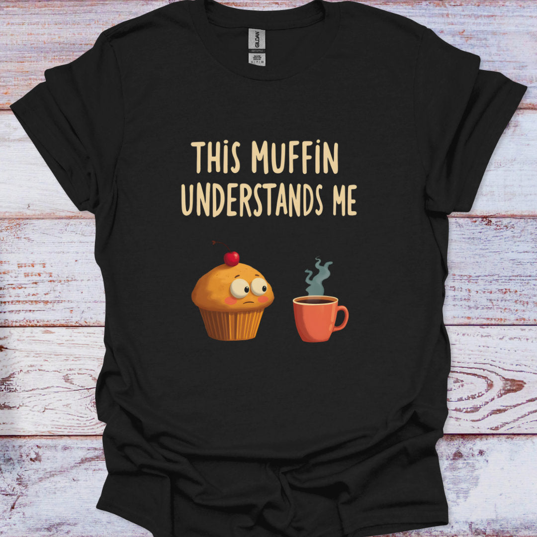 Black t-shirt with a cartoon muffin and coffee cup graphic and text 'This Muffin Understands Me' on a wooden surface.