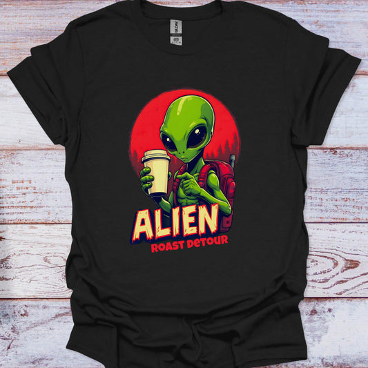 Black t-shirt with an alien graphic holding a coffee cup on a wooden surface