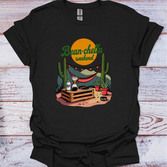 Black t-shirt with a graphic design featuring cacti, a beer can, and text on a wooden surface.