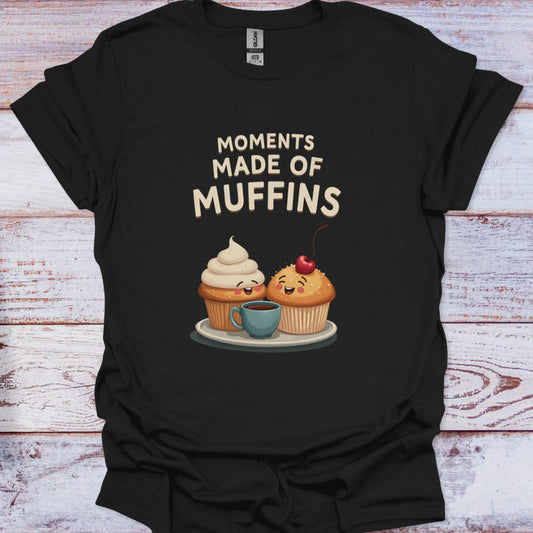 Black t-shirt with cartoon muffins and text 'Moments Made of Muffins' on a wooden surface