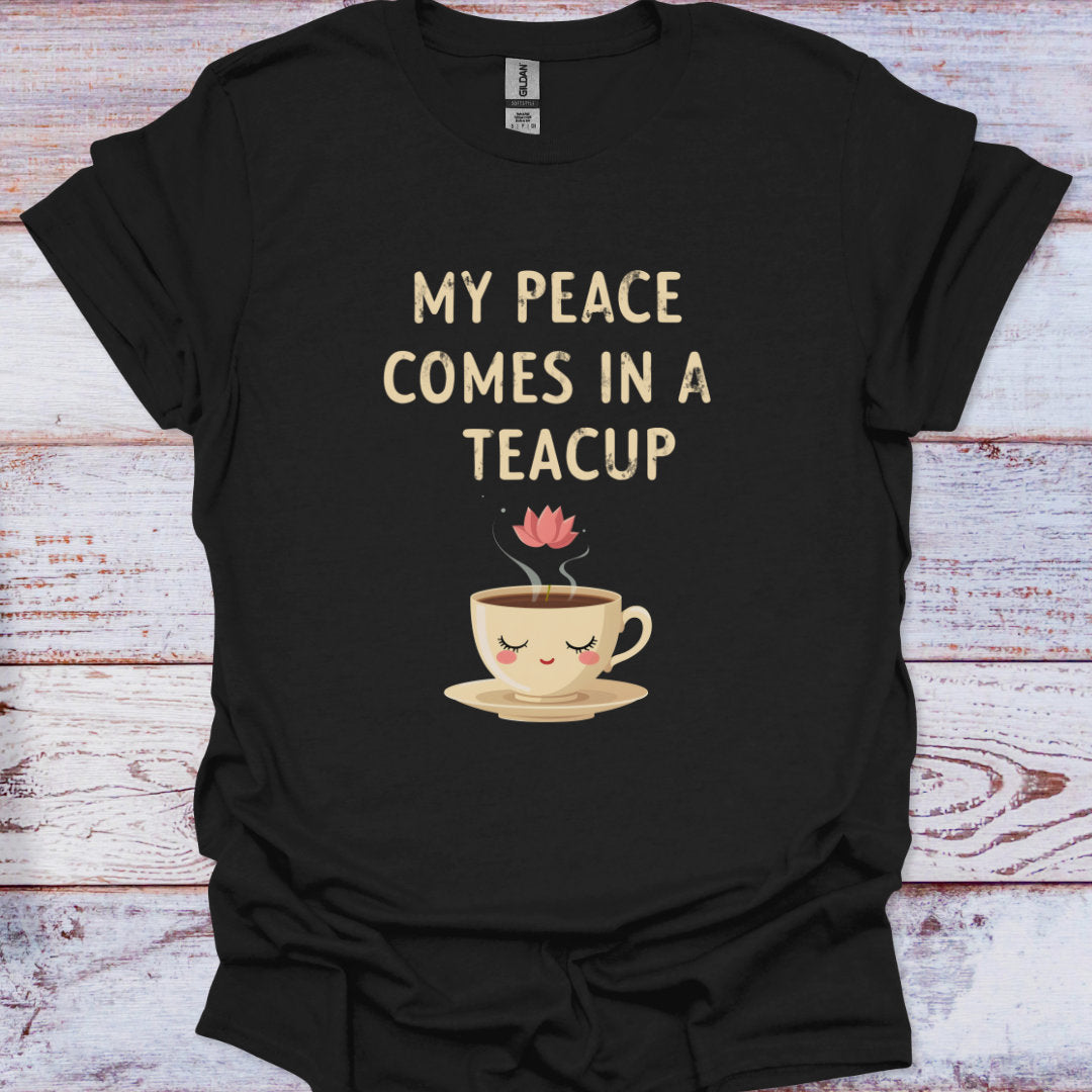 Black t-shirt with a teacup graphic and text on a wooden surface