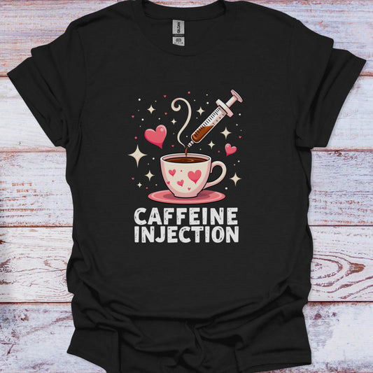Black t-shirt with a graphic of a coffee cup and syringe labeled 'Caffeine Injection' on a wooden surface.