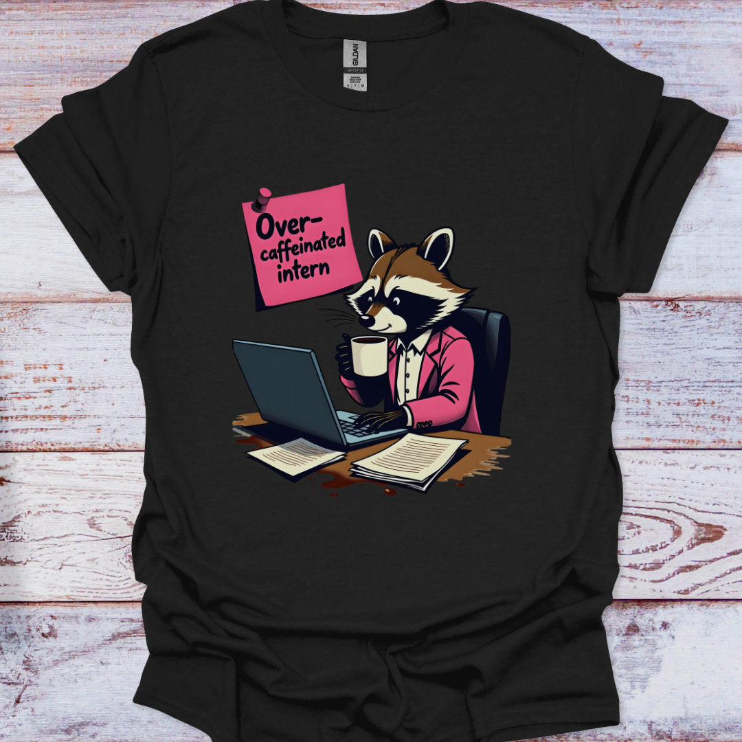 Black t-shirt with a raccoon graphic and 'Over-caffeinated intern' text on a wooden surface