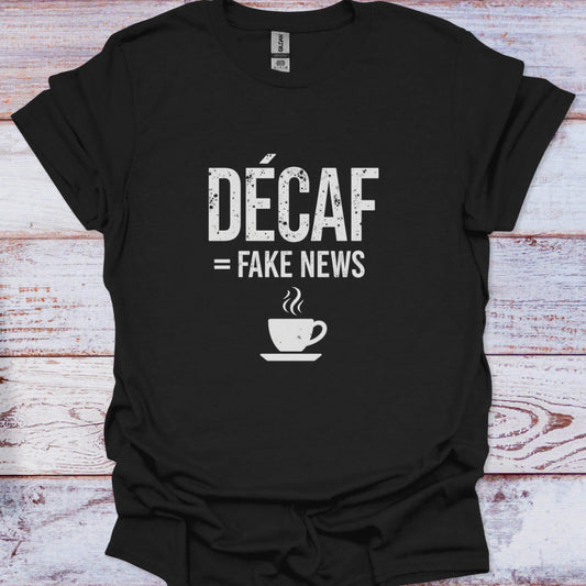 Black t-shirt with 'Décaf = Fake News' text and coffee cup graphic on a wooden surface