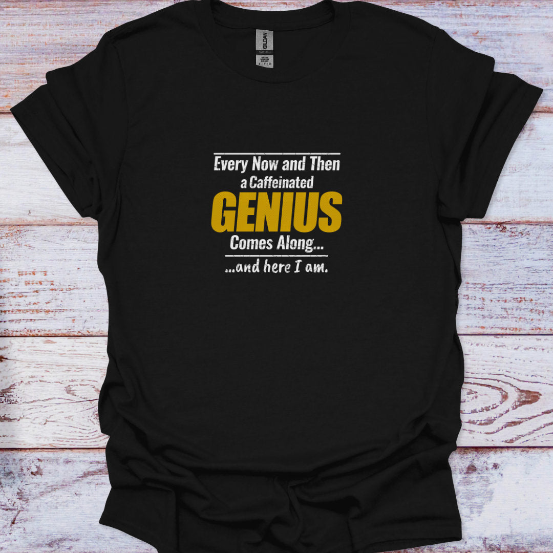 A flat lay of a black t-shirt featuring the text "Every Now and Then a Caffeinated GENIUS Comes Along" in white and mustard yellow distressed fonts.