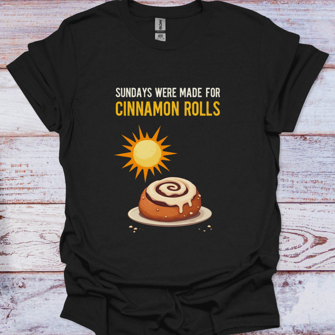 Black t-shirt with a cinnamon roll graphic and text on a wooden surface