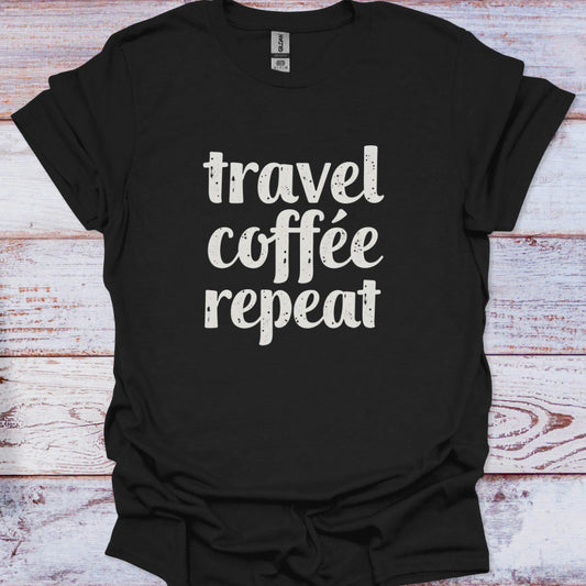 Black t-shirt with 'travel coffee repeat' text on a wooden surface