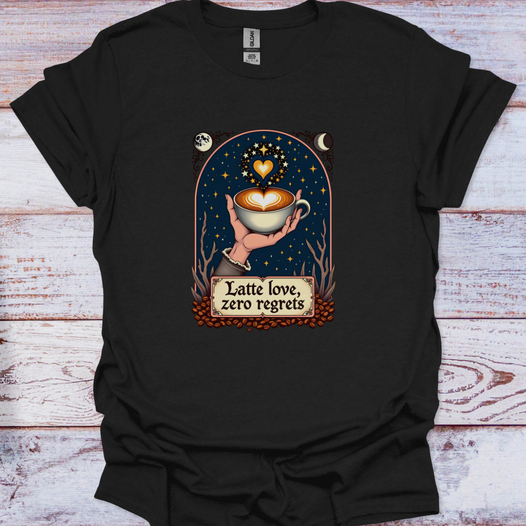 Black t-shirt with a graphic design of a hand holding a coffee cup with a heart, surrounded by stars and moons, on a wooden surface.