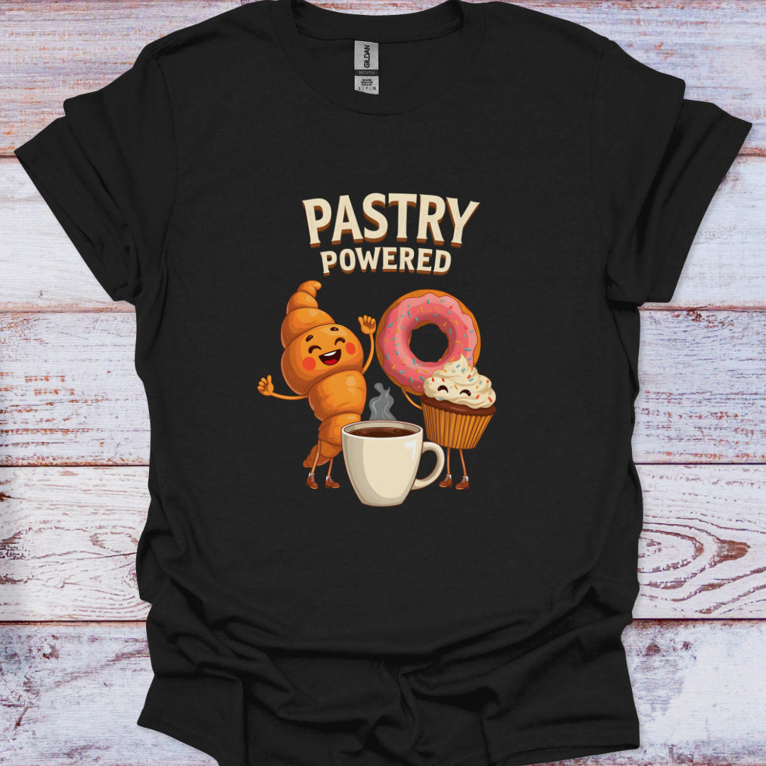 Black t-shirt with cartoon characters and 'Pastry Powered' text on a wooden surface