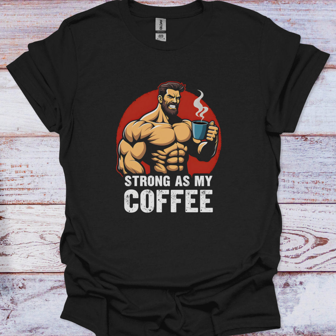 Black t-shirt with a graphic of a muscular man holding a coffee cup and text 'Strong as my coffee' on a wooden surface.