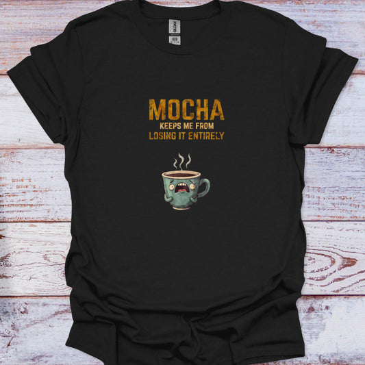 Black t-shirt featuring a terrified cartoon coffee cup and distressed yellow text reading Mocha Keeps Me From Losing It Entirely.
