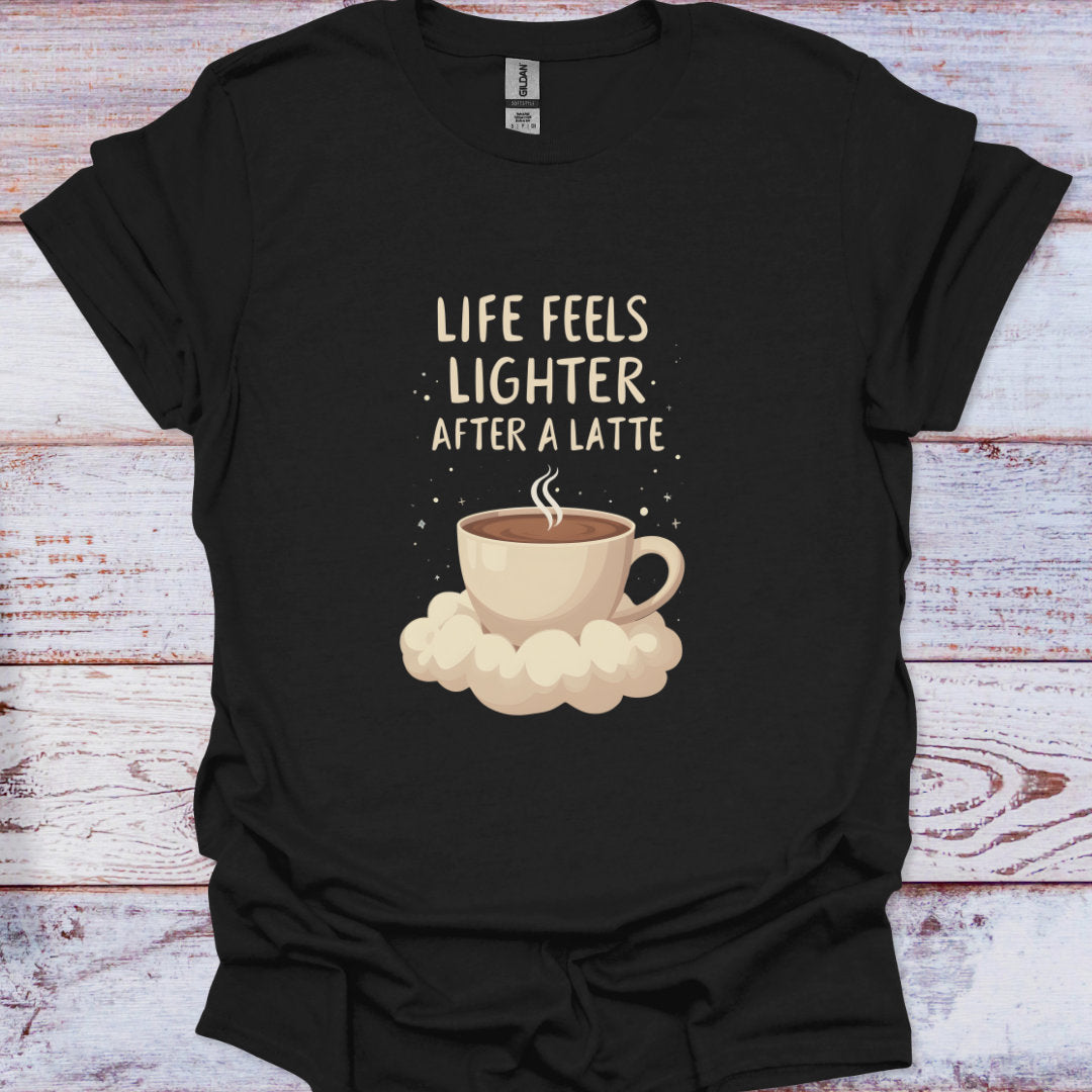 Black t-shirt with a coffee cup graphic and text 'Life feels lighter after a latte' on a wooden surface.