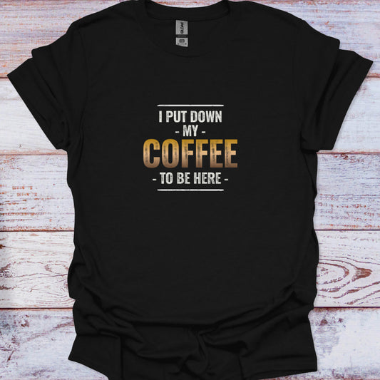 Distressed white and gold gradient text reading "I Put Down My Coffee To Be Here" centered on a black t-shirt.