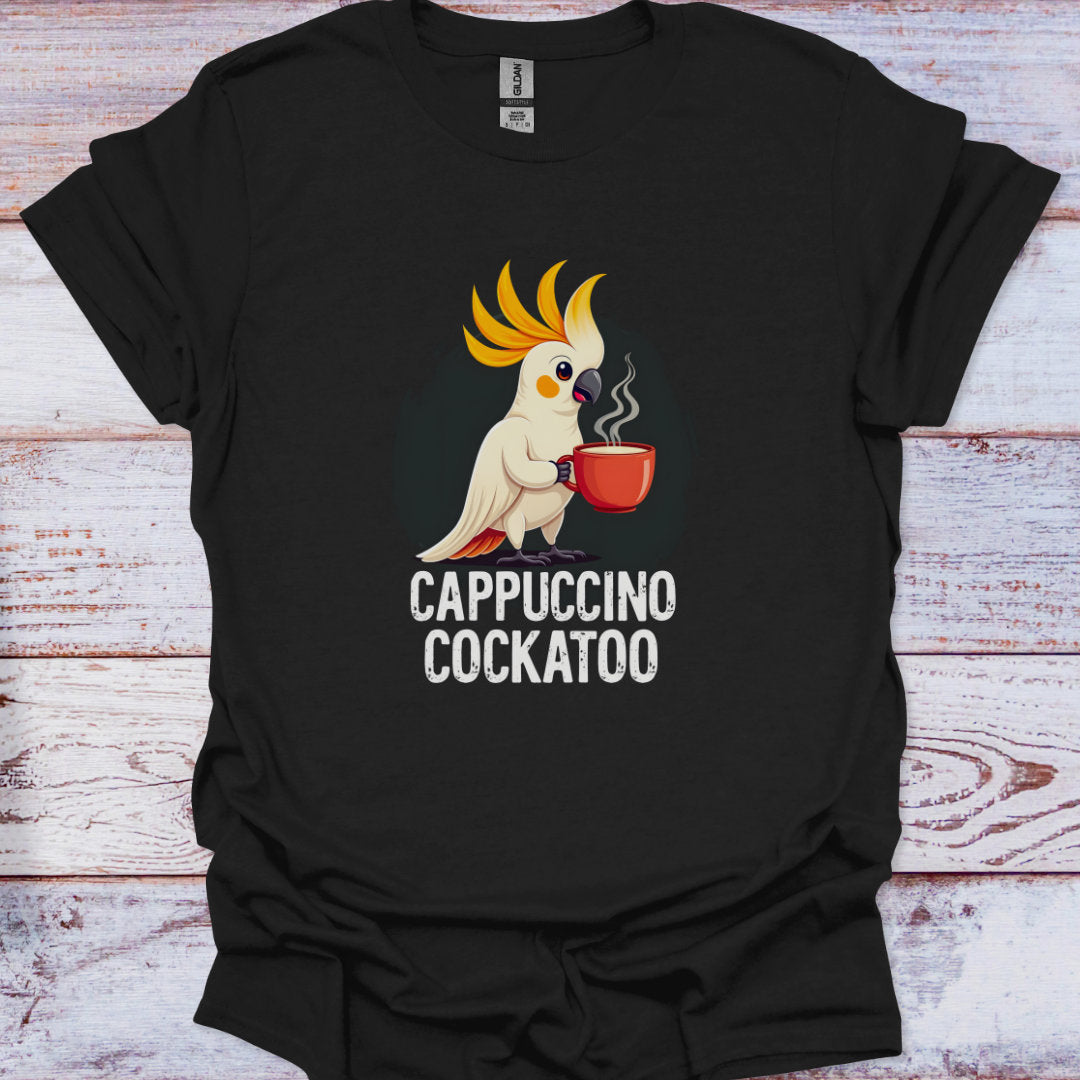 Black t-shirt with a cartoon cockatoo holding a cup labeled 'Cappuccino Cockatoo' on a wooden surface.