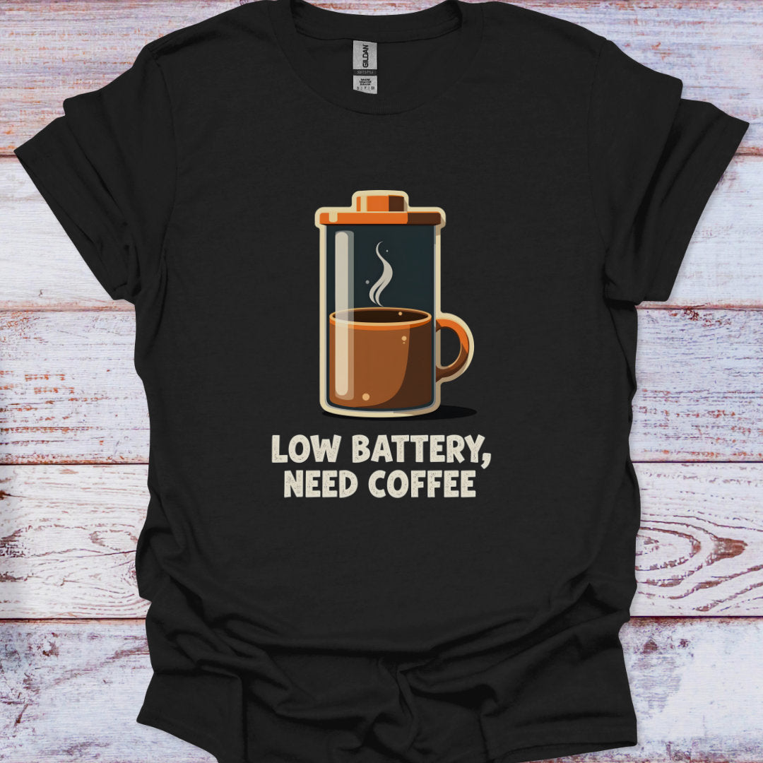 Black t-shirt with a coffee-themed graphic and text 'Low battery, need coffee' on a wooden surface.