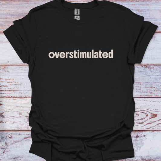 Black t-shirt with 'overstimulated' text on a wooden surface