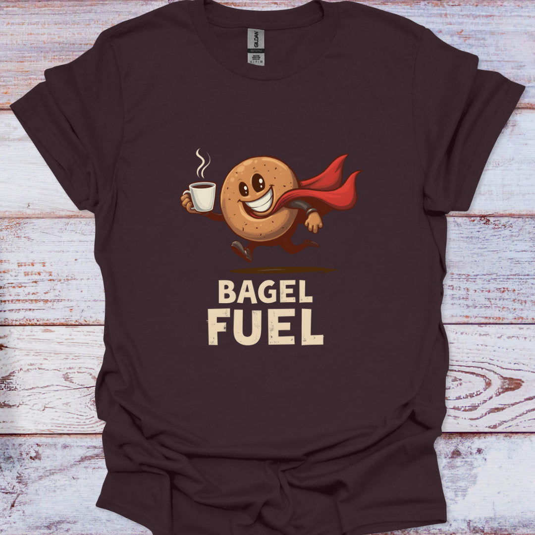 Brown t-shirt with a bagel character holding a coffee cup and 'Bagel Fuel' text on a wooden surface