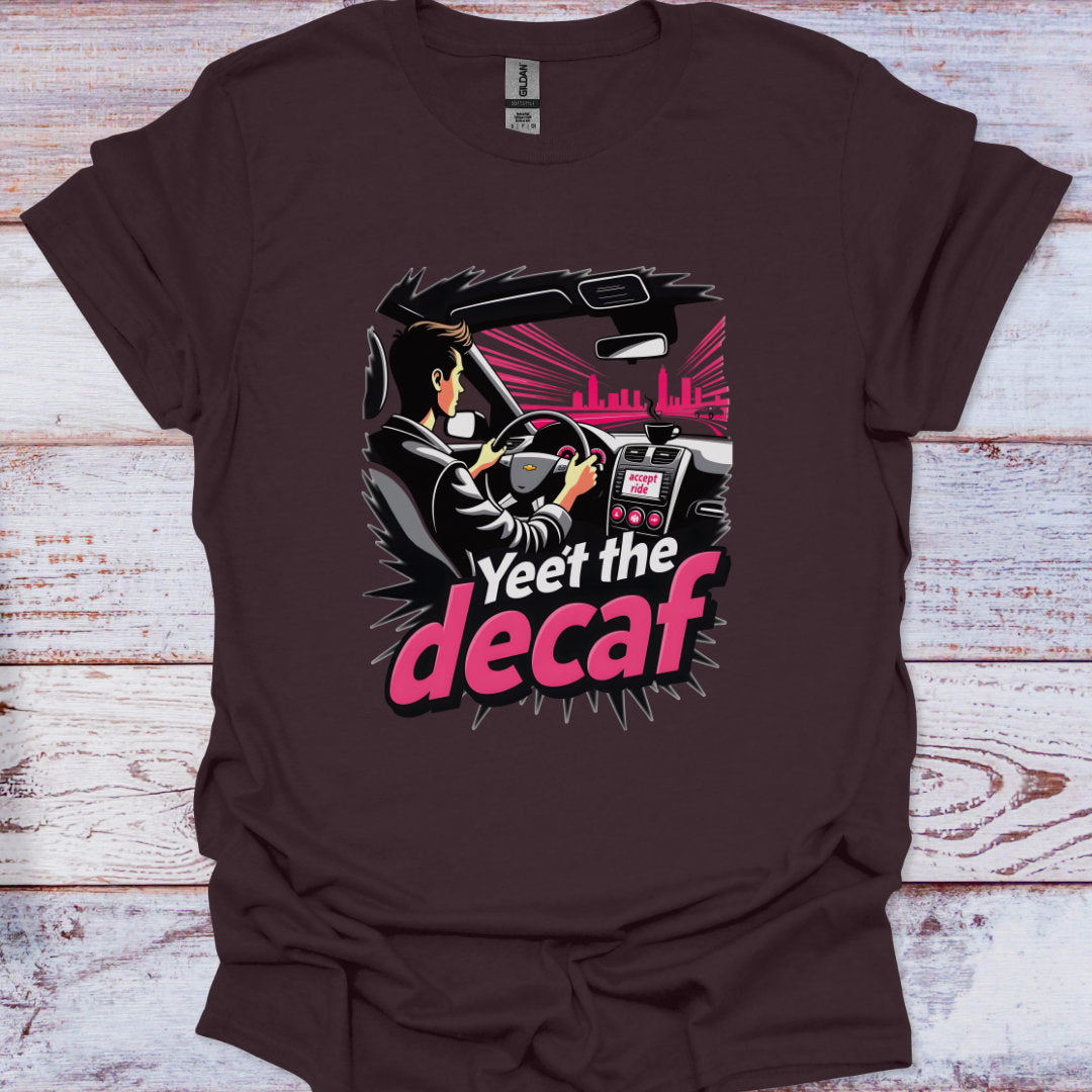 Brown t-shirt with a graphic design of a person driving a car and the text 'Yeet the decaf' on a wooden surface.