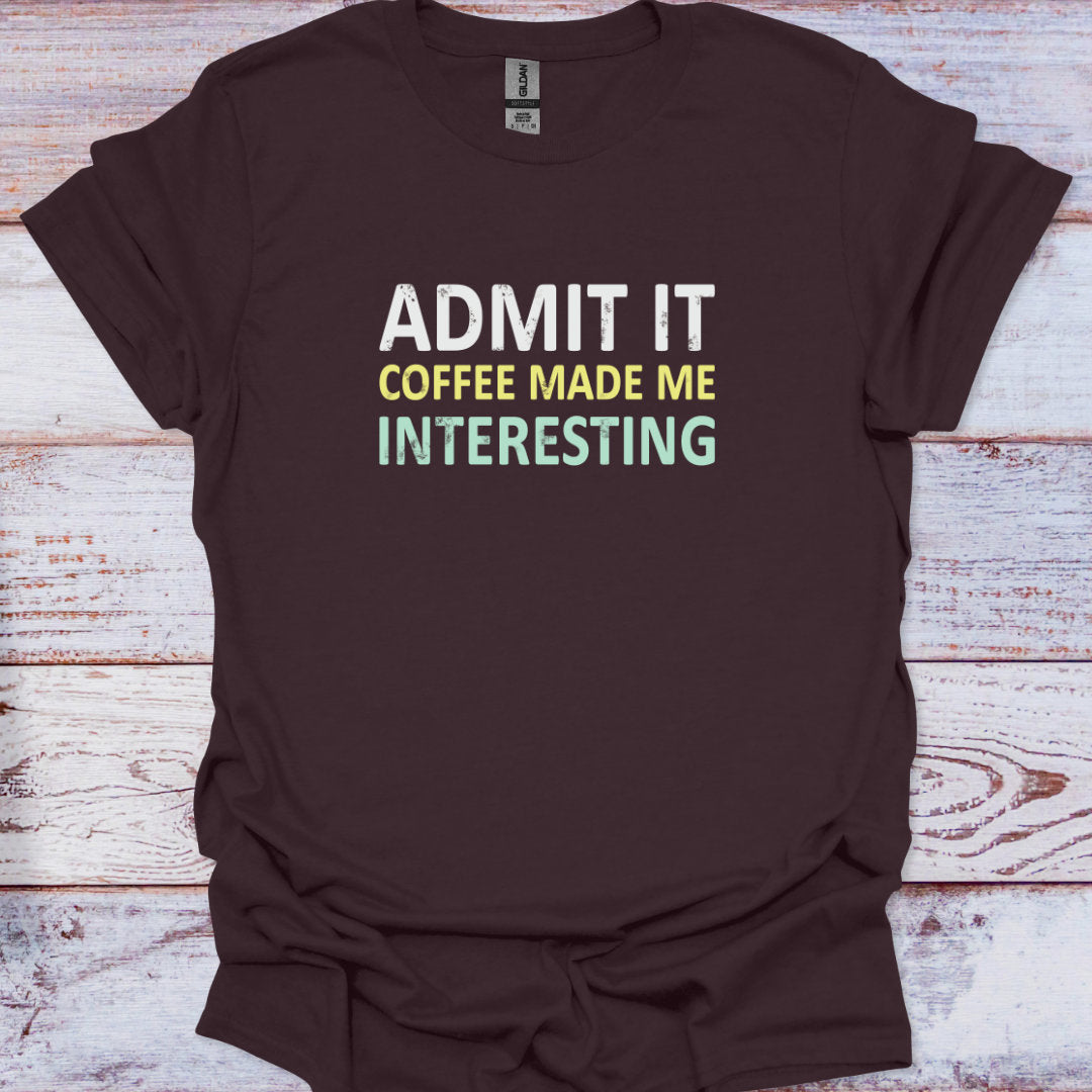 Brown t-shirt with 'Admit It Coffee Made Me Interesting' text on a wooden surface
