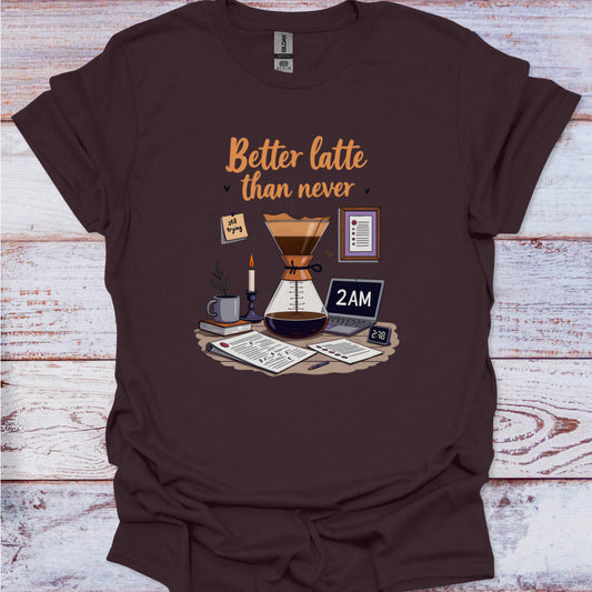 Brown t-shirt with coffee-themed graphic and text 'Better latte than never' on a wooden surface.