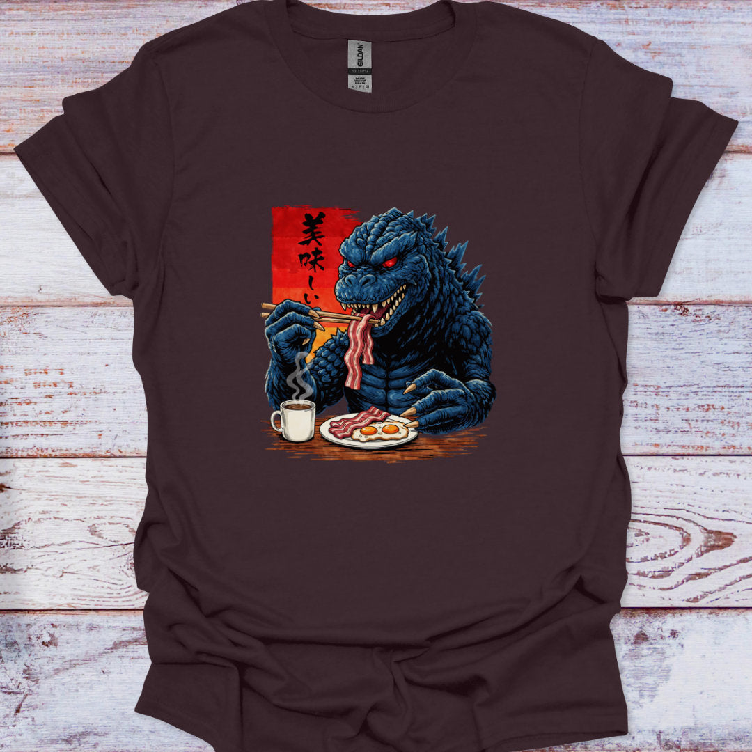 Brown t-shirt with a graphic of a kaiju dragon eating breakfast on a wooden surface