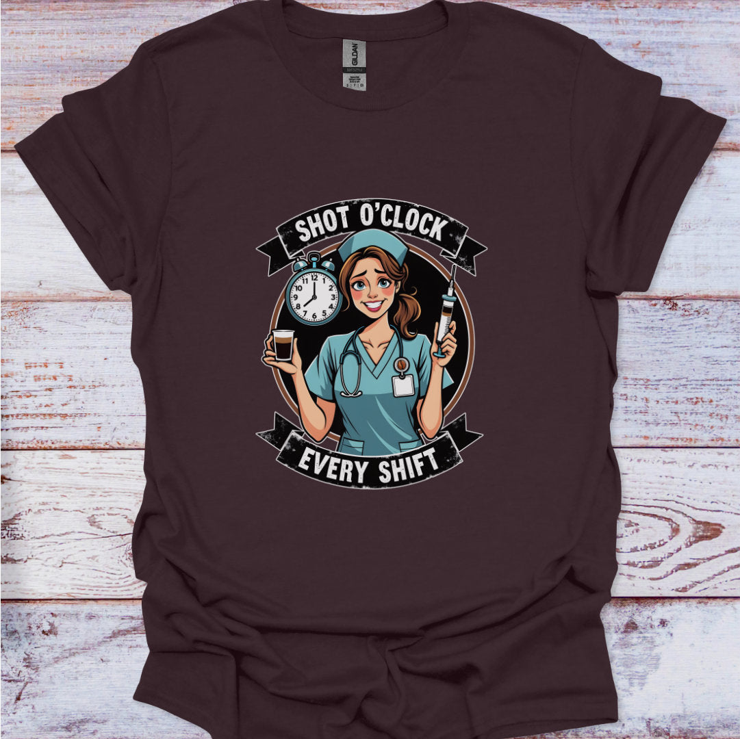 Brown t-shirt with a graphic of a nurse and text 'Shot O'Clock Every Shift' on a wooden surface.