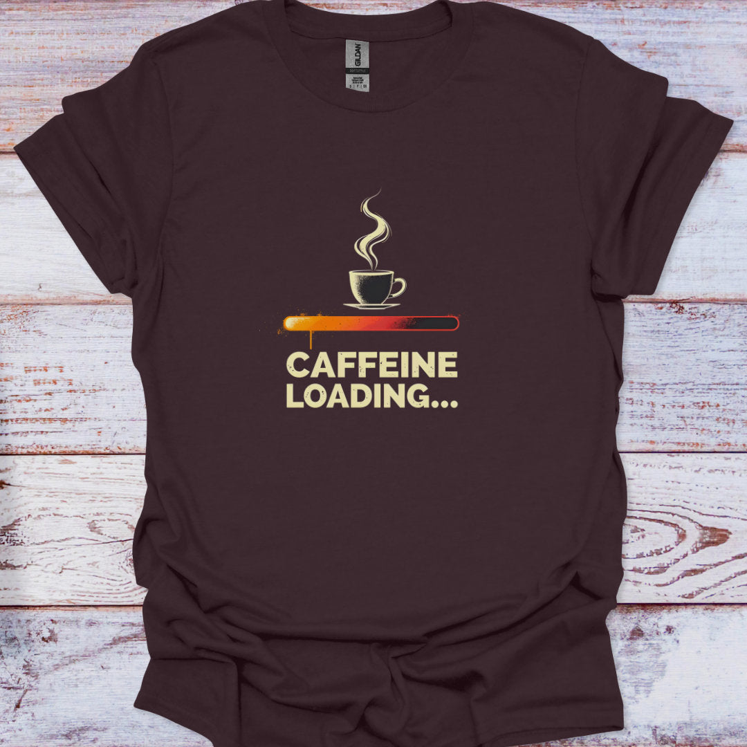 Brown t-shirt with a coffee cup and 'CAFFEINE LOADING...' text on a wooden surface