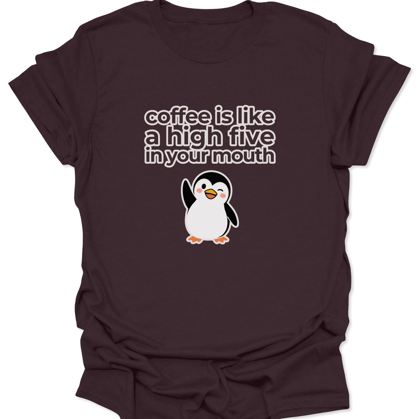 A dark chocolate brown t-shirt featuring a white and yellow cartoon penguin winking and waving below the text "coffee is like a high five in your mouth" in a bold, rounded font.