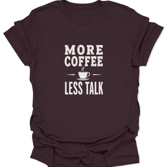 Dark brown t-shirt featuring a central white typographic graphic demanding 'MORE COFFEE LESS TALK' with a small, stylized steam cup illustration.