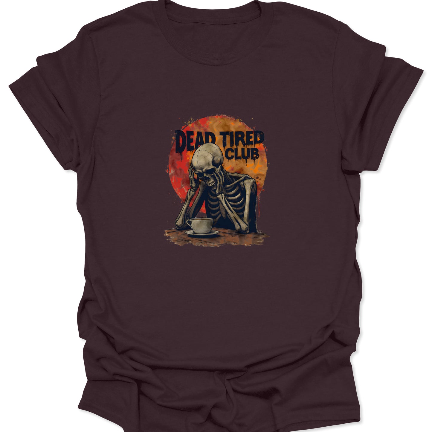 Dark brown t-shirt featuring the Dead Tired Club skeleton graphic with a cup of coffee and an orange/red sun background, depicting extreme exhaustion.