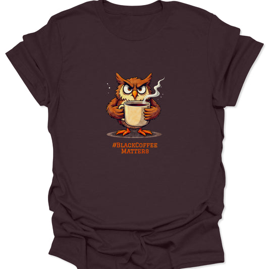 Dark chocolate brown shirt featuring an irritated, brown and orange owl holding a coffee cup. Design is centered with the black coffee hashtag underneath.