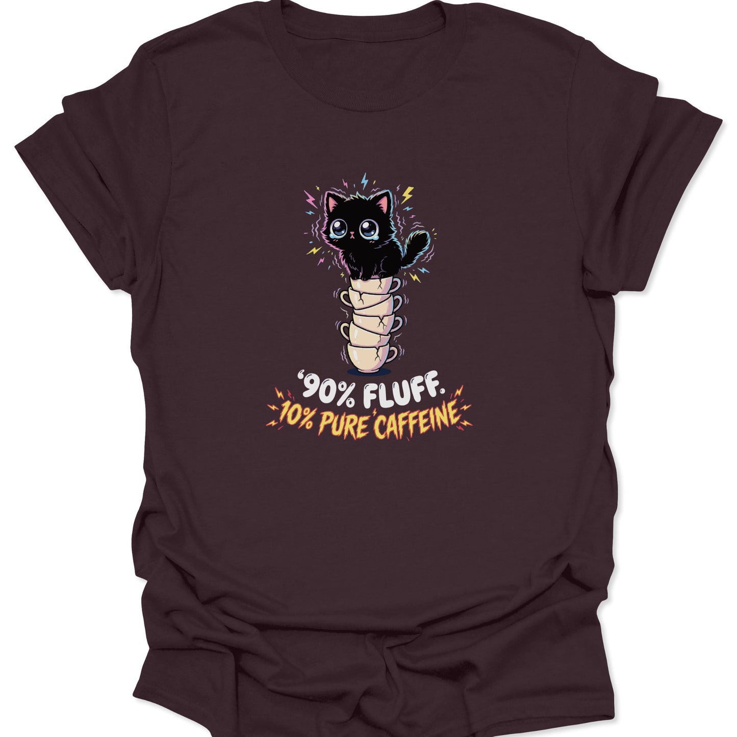 Graphic tee on a dark chocolate brown fabric background featuring a wide-eyed, vibrating black cat sitting on five stacked, cracked coffee cups with the text "90% Fluff 10% Pure Caffeine" in bold, jagged letters.