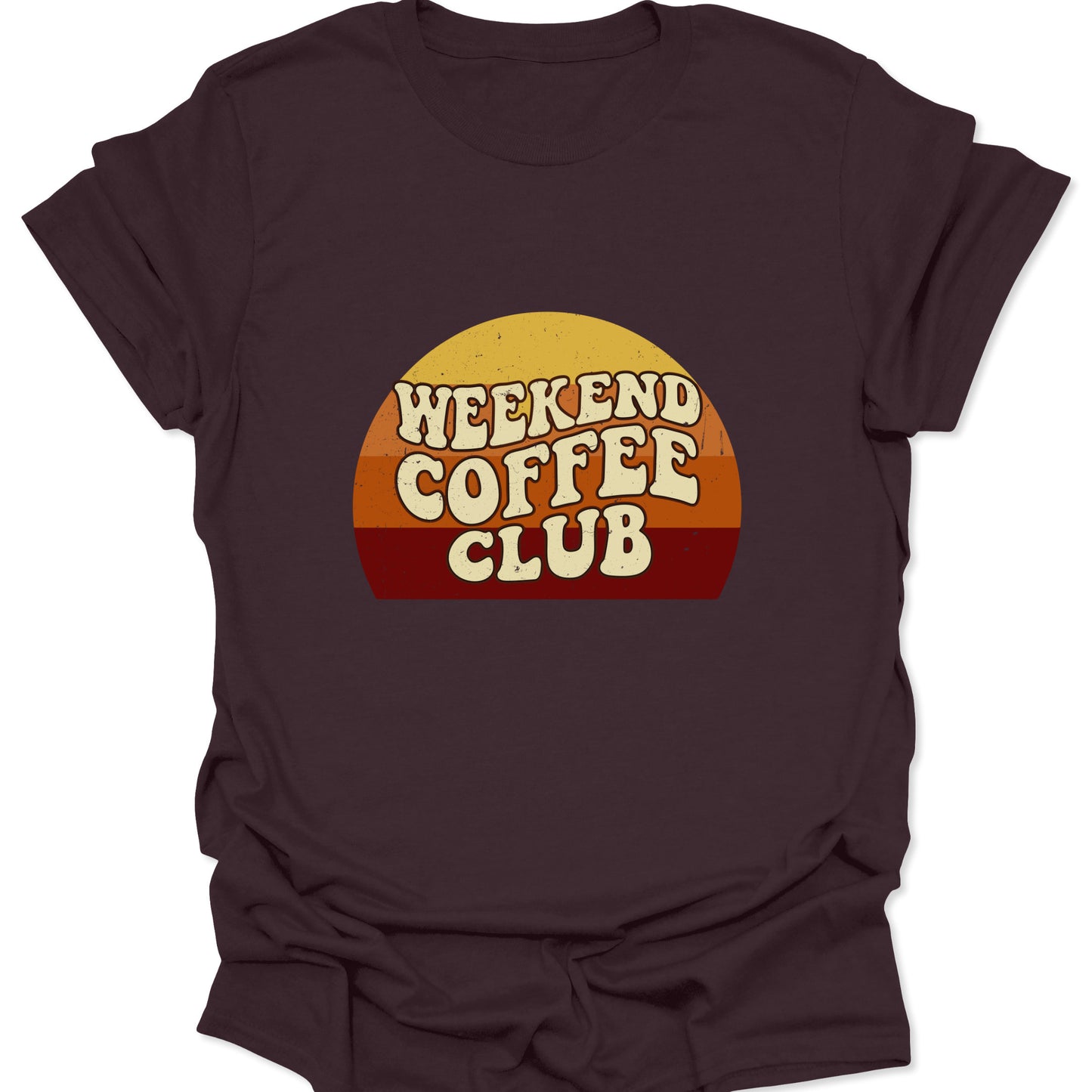 Graphic tee on a dark chocolate brown fabric background featuring a retro sunset semi-circle with "Weekend Coffee Club" text in a cream-colored, bubbly 70s font.