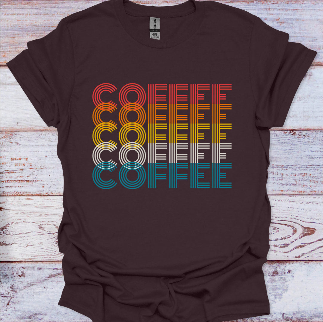 Brown t-shirt with 'COFFEE' graphic in multicolor on a wooden surface