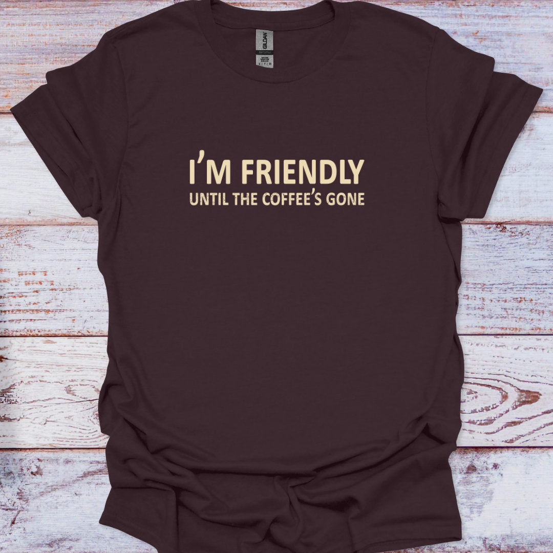Brown t-shirt with 'I'm Friendly Until the Coffee's Gone' text on a wooden surface