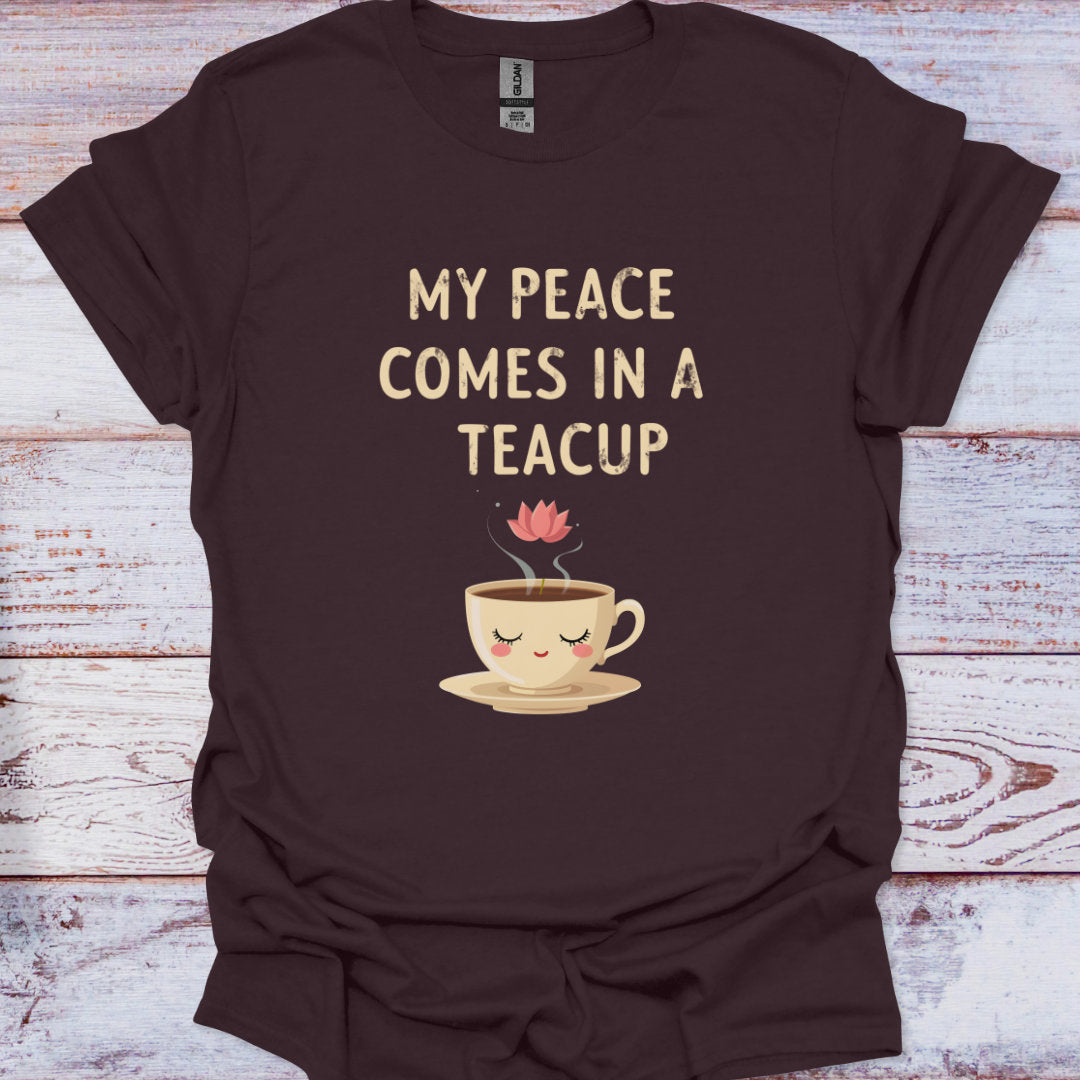 Brown t-shirt with a teacup graphic and text on a wooden surface