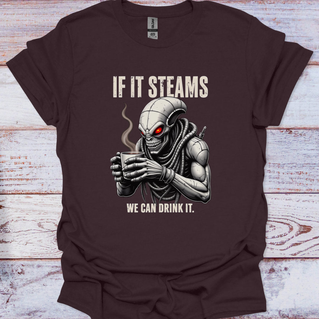 Brown t-shirt with alien holding a steaming cup graphic and text on a wooden surface