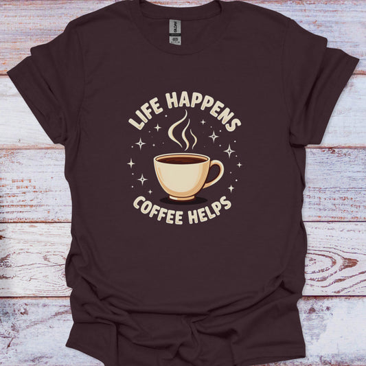 Brown t-shirt with 'Life Happens Coffee Helps' graphic on a wooden surface