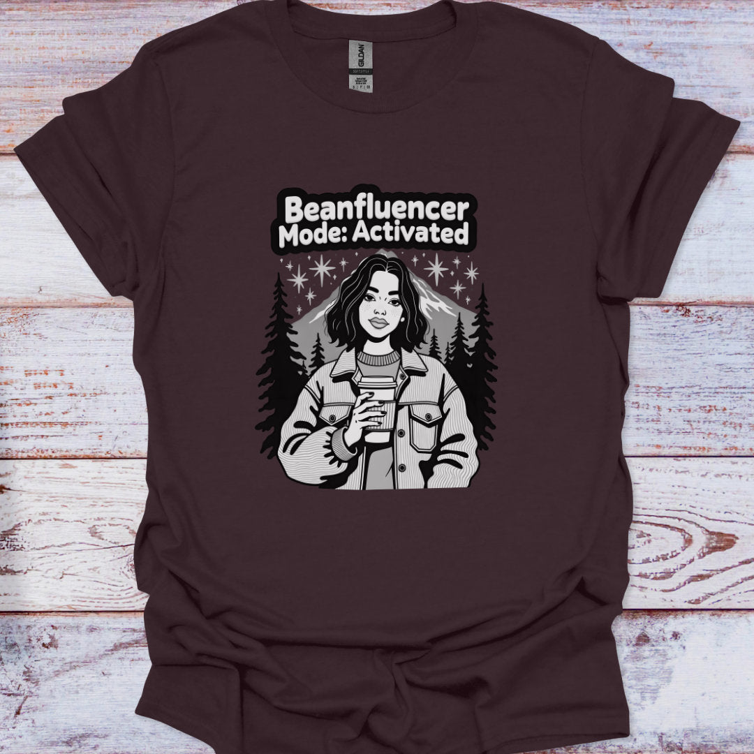 Brown t-shirt with graphic design and text 'Beanfluencer Mode: Activated' on a wooden surface
