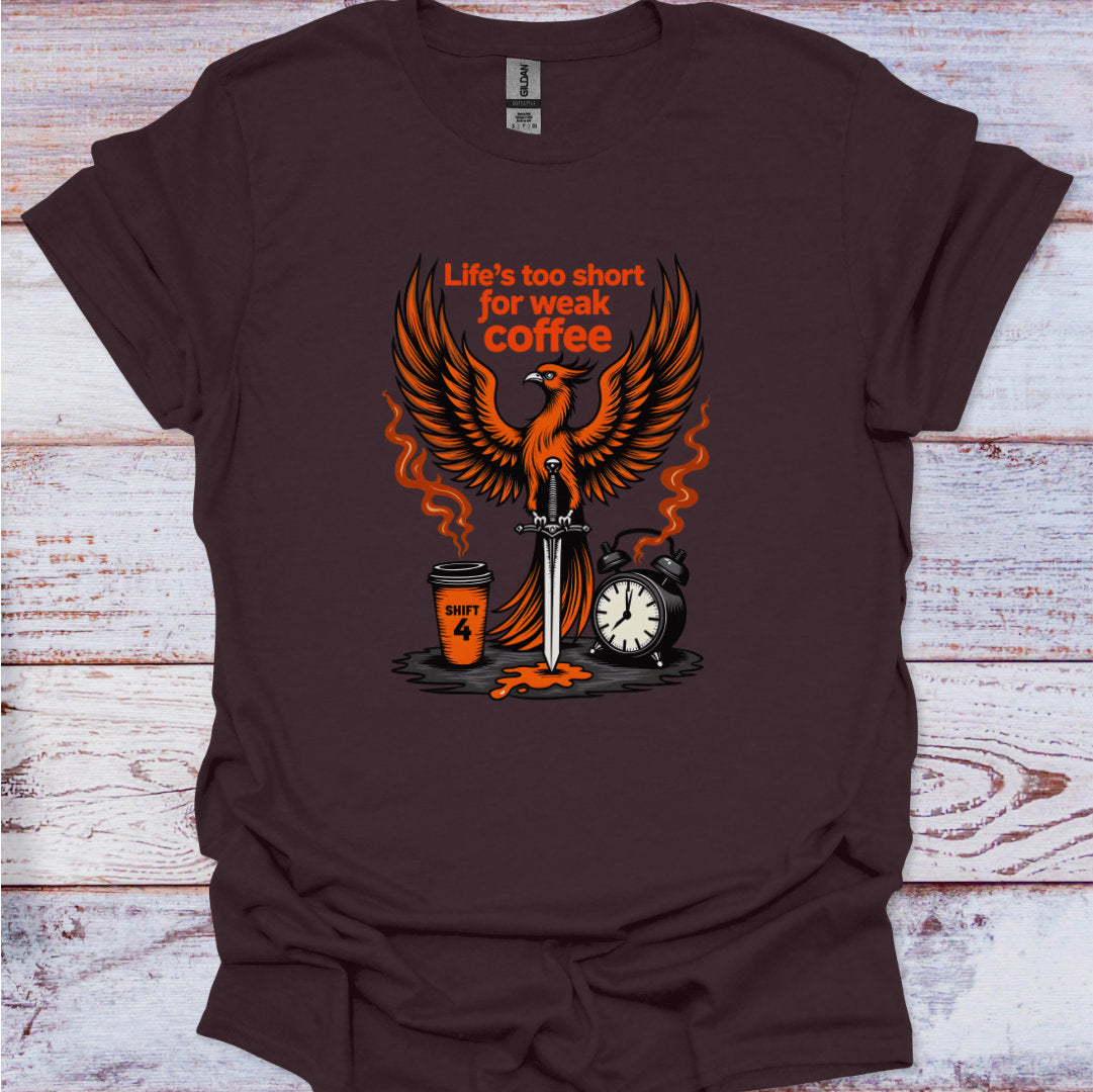 Brown t-shirt with a graphic design featuring an phoenix, coffee cup, sword, and alarm clock on a wooden surface.