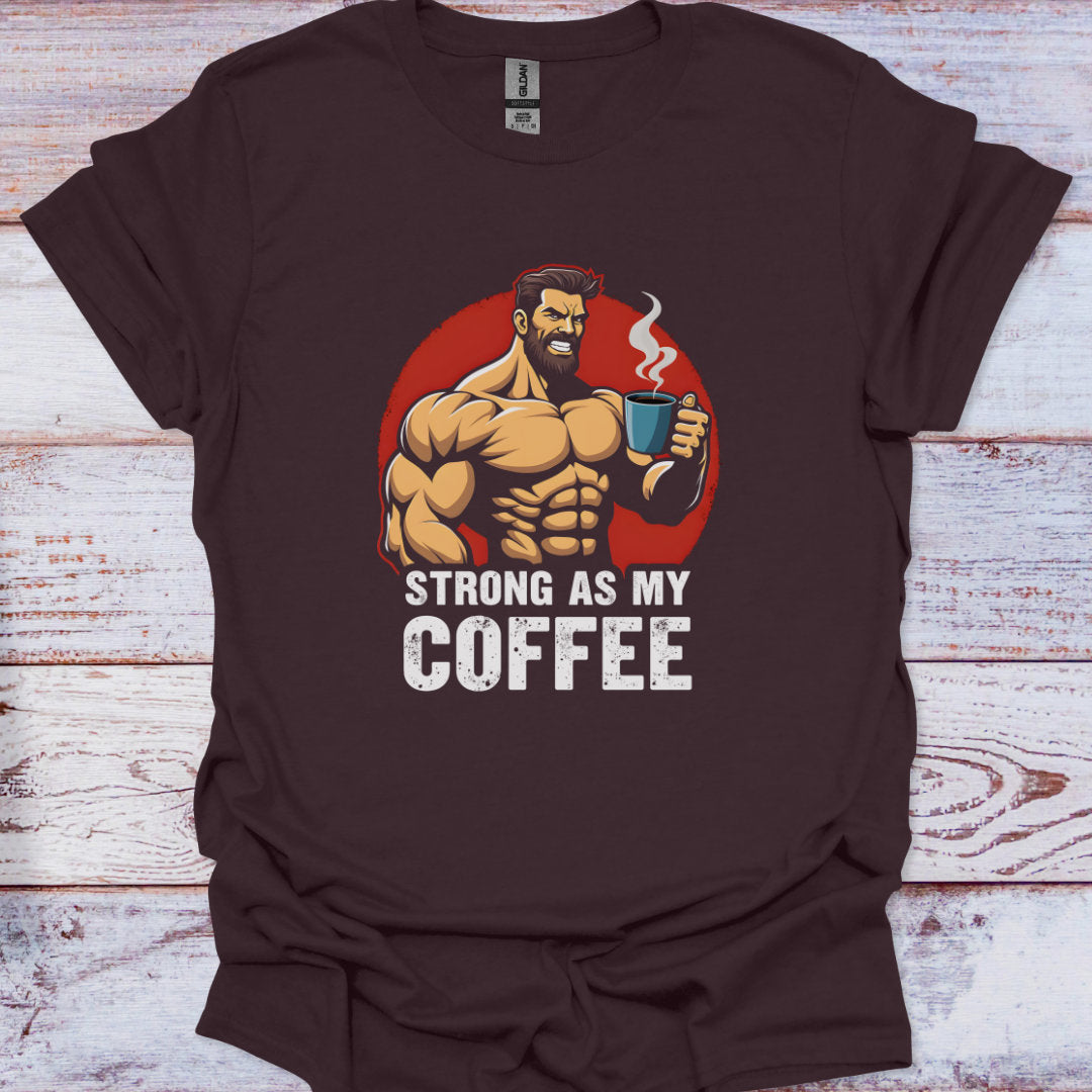 Brown t-shirt with a graphic of a muscular man holding a coffee cup and text 'Strong as my coffee' on a wooden surface.