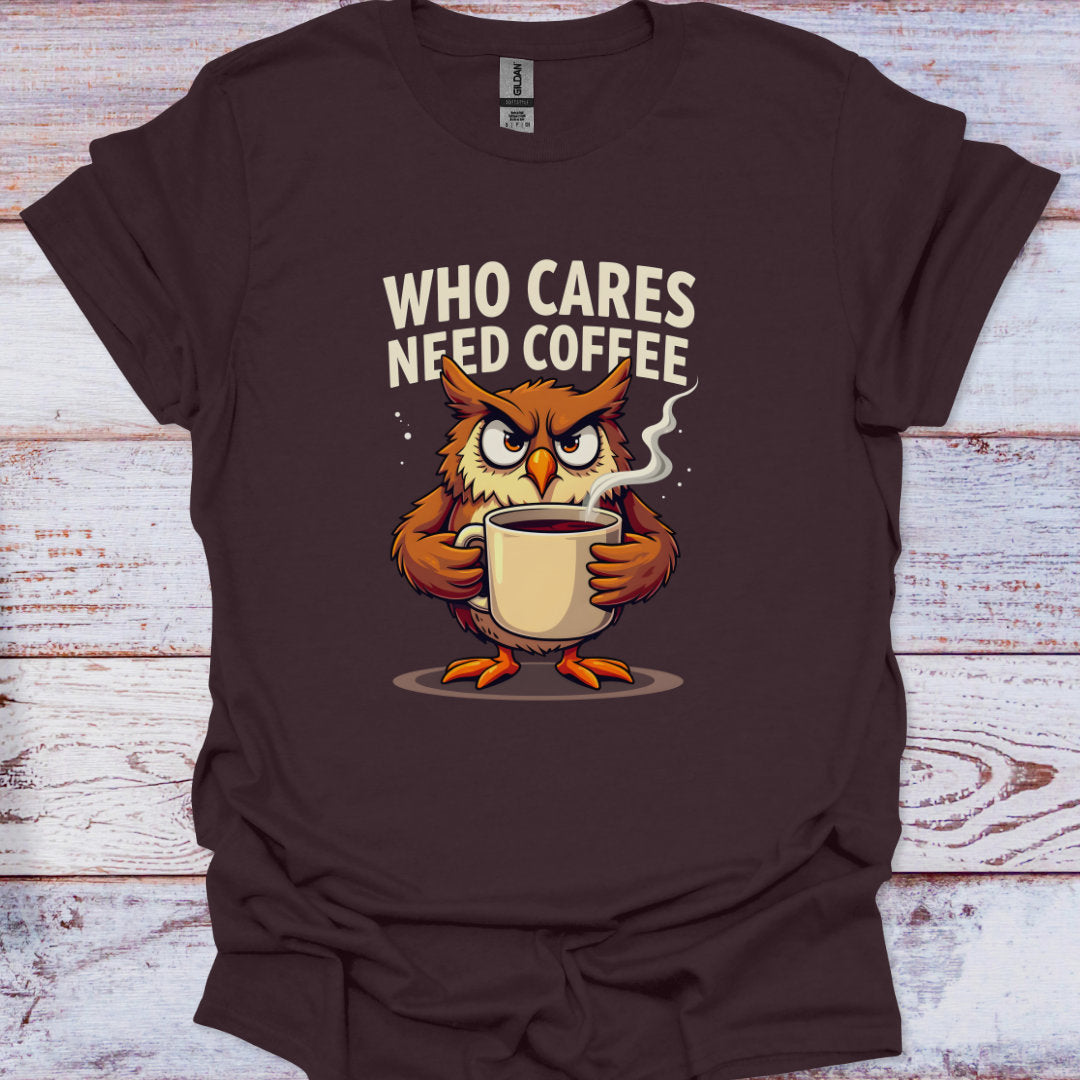 Brown t-shirt with an owl holding a coffee cup and text 'WHO CARES NEED COFFEE' on a wooden surface.