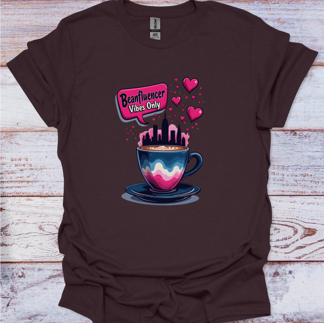 Brown t-shirt with a colorful coffee cup graphic and text on a wooden surface