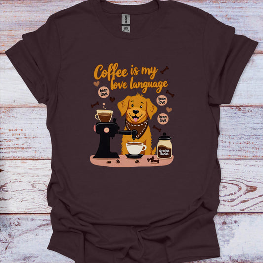 Brown t-shirt with a graphic of a dog making coffee and text 'Coffee is my love language' on a wooden surface.