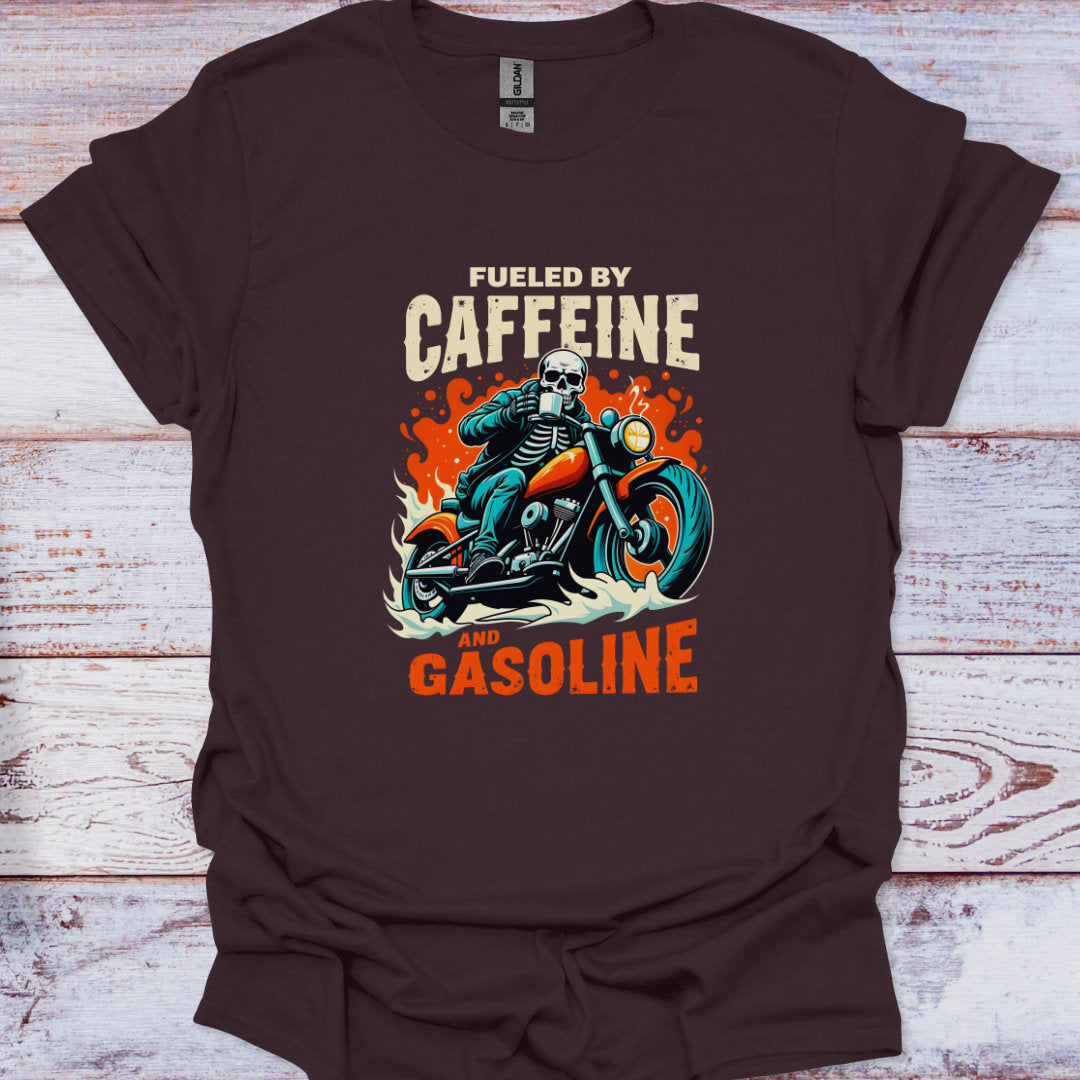 Brown t-shirt with skeleton on a motorcycle graphic and text 'Fueled by Caffeine and Gasoline' on a wooden surface.