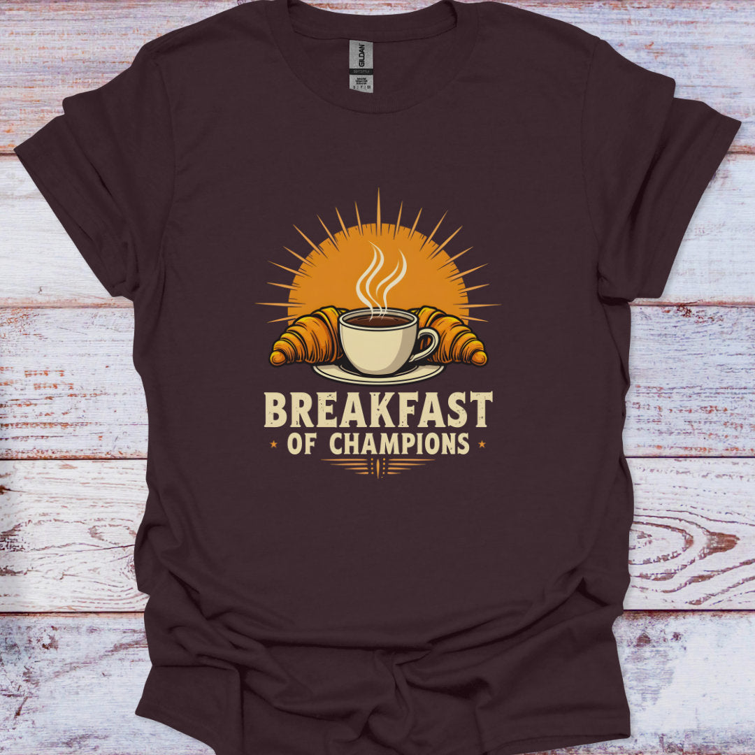 Brown t-shirt with 'Breakfast of Champions' graphic on a wooden surface