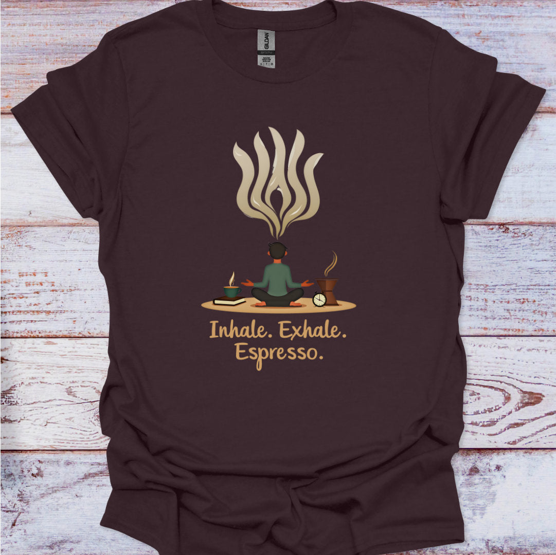 Brown t-shirt with a graphic of a person meditating and flames, with 'Inhale. Exhale. Espresso.' text on a wooden surface.