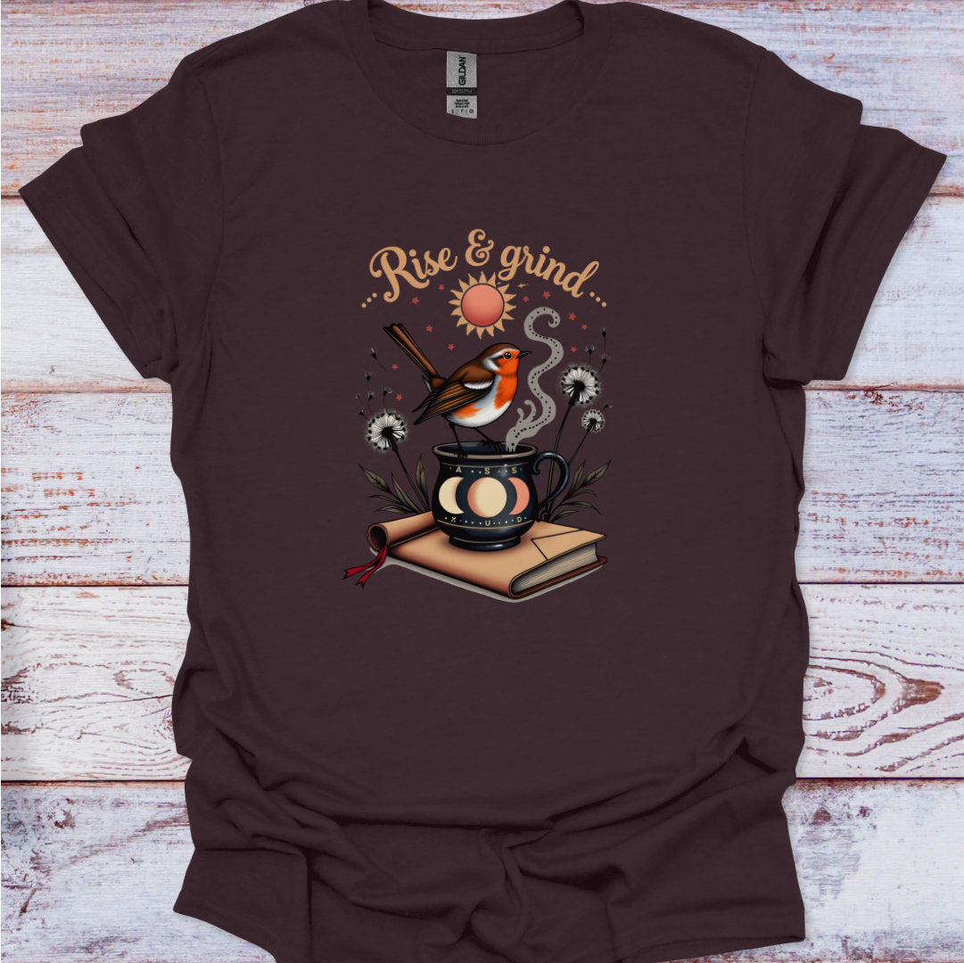 Brown t-shirt with 'Rise & Grind' graphic design featuring a bird, sun, and coffee cup on a wooden surface.