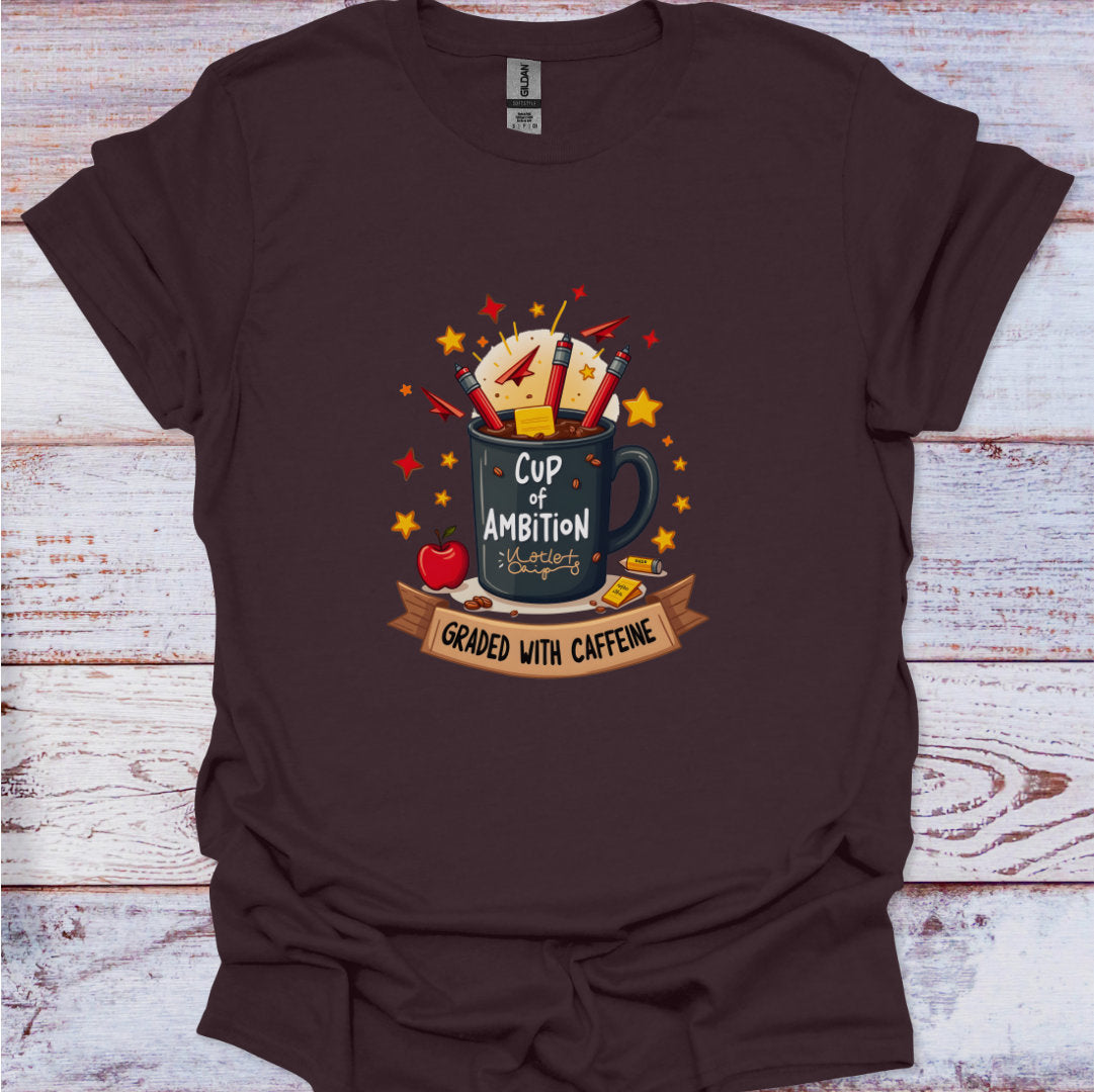 Brown t-shirt with a graphic design of a mug labeled 'Cup of Ambition' on a wooden surface.
